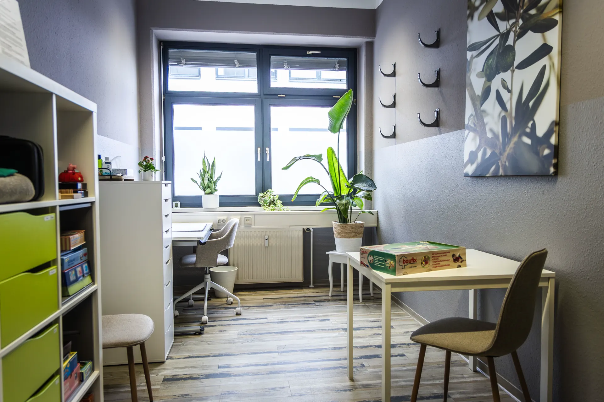 Ergotherapieraum mit Arbeitsplatz und Materialregal in der 360° Therapie Kesselsdorf